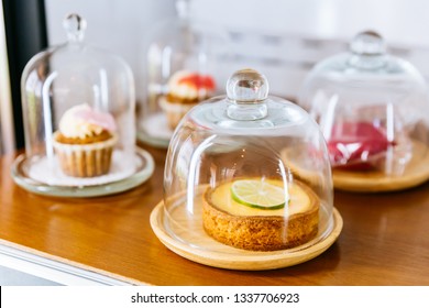 Mini Key Lime Pie Topping With Slice Of Lime In Wooden Plate And Cover With Glass Cloche.