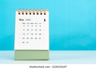 The mini May 2022 desk calendar on blue background.