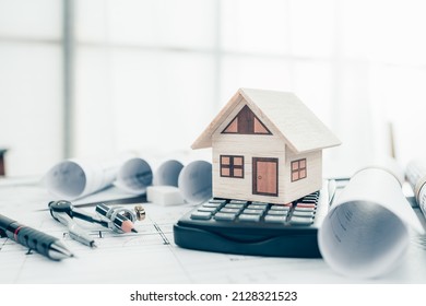 Mini model house on calculator, pencil, compass  and roll blueprint plan  on blueprint house plan design. Cost Architect and engineer concept. - Shutterstock ID 2128321523