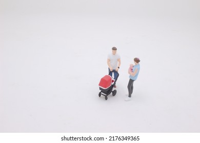 The Mini Of Mother And Father Walking Outdoors And Pushing Baby In Pram