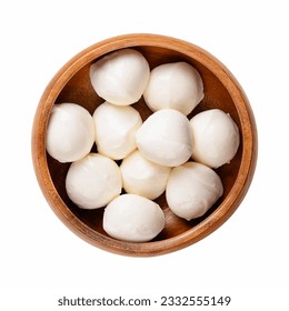 Mini mozzarella balls, in a wooden bowl. Fresh white southern Italian cheese made from milk by the pasta filata method, also called bambini bocconcini. Used for pizza, pasta dishes or Caprese salad.