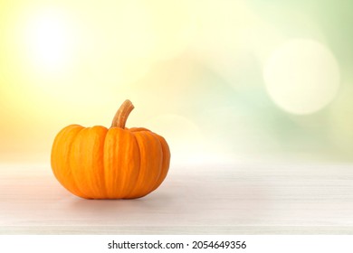 Mini Orange Pumpkin Isolated On Green Bokeh Wall With Beige Wooden Floor Product Background