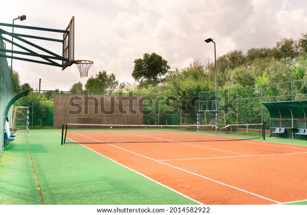 Mini outdoor sports ground, facilities for training\
and playing football, basketball, volleyball and tennis court.\
Active recreation in the park on a summer day surrounded by\
trees