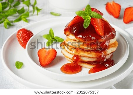 Mini pancakes with strawberry jam and strawberries