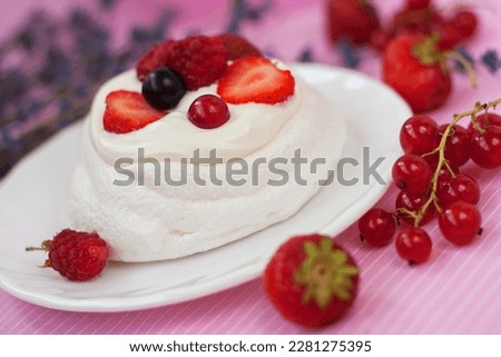 Mini Pavlova Cake dessert with fresh strawberries, black and red currants. Summer dessert with berries. French cake