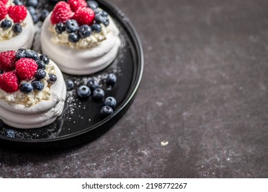 Mini Pavlova Cakes Topped With Berries And Mascarpone Cheese