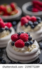 Mini Pavlova Cakes Topped With Berries And Mascarpone Cheese