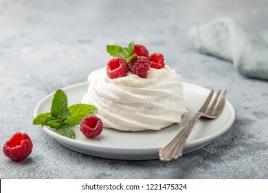 mini pavlova  meringue cake with whipped cream and fresh raspberry, selective focus