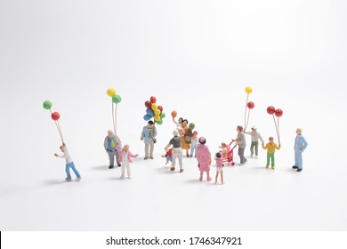 Mini People With Family Holding Balloon On The Board