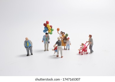 Mini People With Family Holding Balloon On The Board