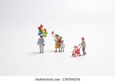 Mini People With Family Holding Balloon On The Board