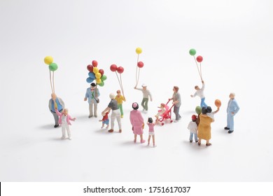 Mini People With Family Holding Balloon On The Board