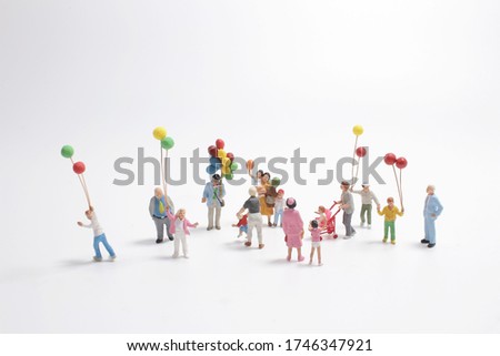 mini people with family holding balloon on the board