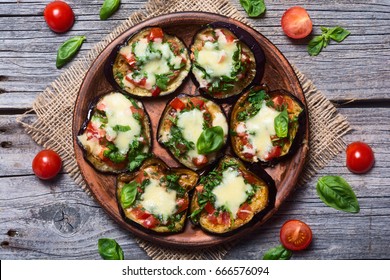 Mini pizza with eggplant , tomato and basil . Top view