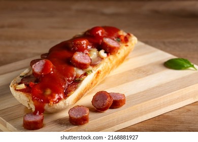 Mini Pizza With Sausages And Tomato Ketchup On A Wooden Cutting Board