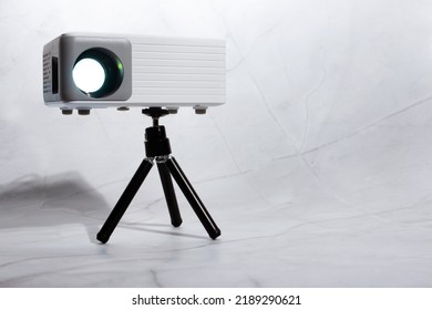 mini projector for home on tripod on light background