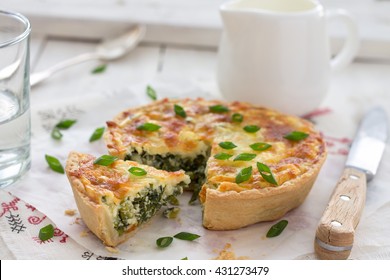 Mini quiche with green onions and cheese on a light wooden background, selective focus