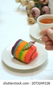 A Mini Rainbow Roll Cake On The White Plate 