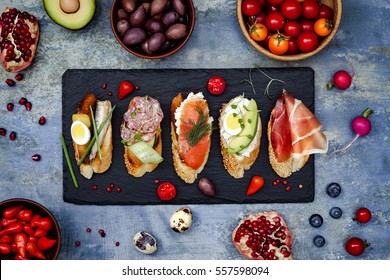 Mini sandwiches food set. Brushetta or authentic traditional spanish tapas for lunch table. Delicious snack, appetizer, antipasti on party or picnic time. Top view. - Shutterstock ID 557598094