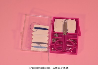Mini sewing kit on a pink background