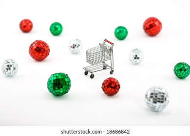 Mini Shopping Cart With Shiny Disco Balls In Christmas Colors On White