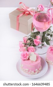Mini small cake with pink glaze, beautiful roses, cup of coffee, gift box on the white table. - Shutterstock ID 1646639485