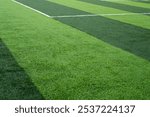 A mini soccer or futsal field with synthetic grass, featuring clean, parallel white lines. Ideal for soccer-themed backgrounds or sports concepts, capturing a modern, energetic sports vibe.