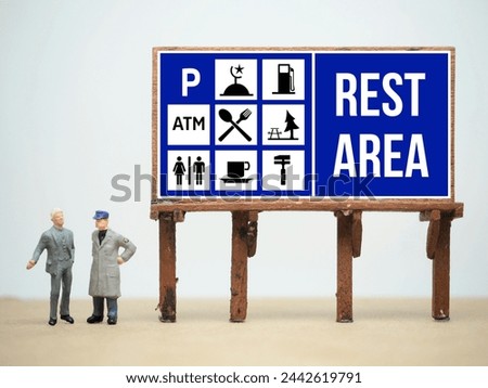 Mini toy of action figure at table with blurred background. Toy photography concept. Rest Area sign at toll road conceptual design.