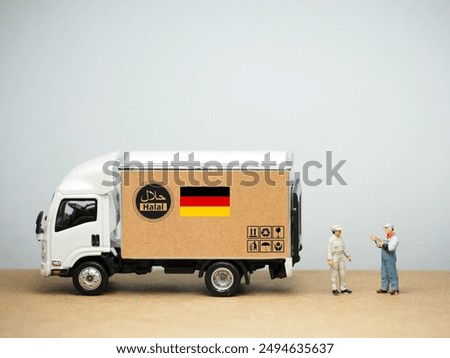 Mini toy of action figure at table with blurred background. Toy photography concept. Industrial shipping concept. Halal logo and German flag design. Fresh and healthy food.