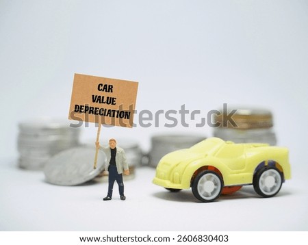 Mini toy of action figure at table with blurred background. Automotive industry photography concept design. Minifigure of people character with CAR VALUE DEPRECIATION poster banner.