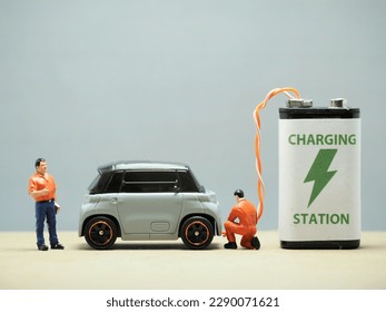 Mini toy at table with blurred background. Electric Car concept design.