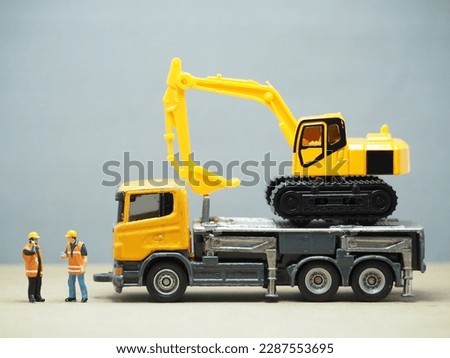 Mini toy at table with blurred background. Transporter and towing Truck.