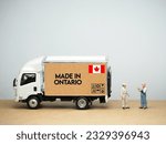 Mini toy at table with white background. Industrial shipping concept. Made in Ontario design, is one of the thirteen provinces and territories of Canada.