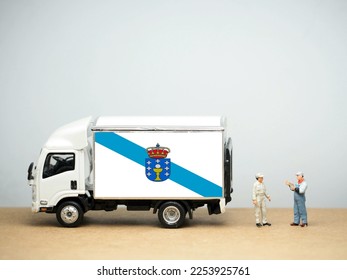Mini toy at table with white background. Industrial shipping concept. Galicia flag design, is an autonomous community of Spain and historic nationality under Spanish law. - Shutterstock ID 2253925761