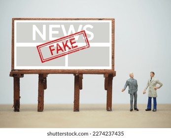 Mini toy at table with white background. Fake news concept.