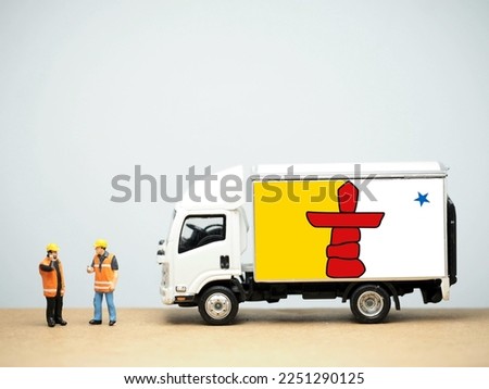 Mini toy at table with white background. Industrial shipping concept. Nunavut flag design. Nunavut is the largest and northernmost territory of Canada.