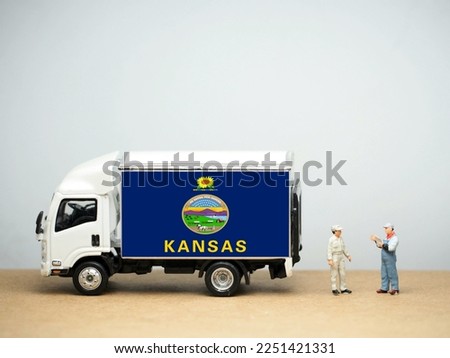Mini toy at table with white background. Industrial shipping concept. Kansas flag design, is a state in the Midwestern United States. Its capital is Topeka, and its largest city is Wichita.