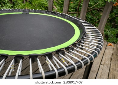 mini trampoline for fitness exercising and rebounding in a backyard patio, spring scenery