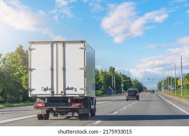 Mini Truck Driving On Highway On Sunny Day. White Modern Delivery Small Shipment Cargo Courier Truck Moving Fast On Motorway Road To City Urban Suburb. Busines Distribution Logistics Express Service