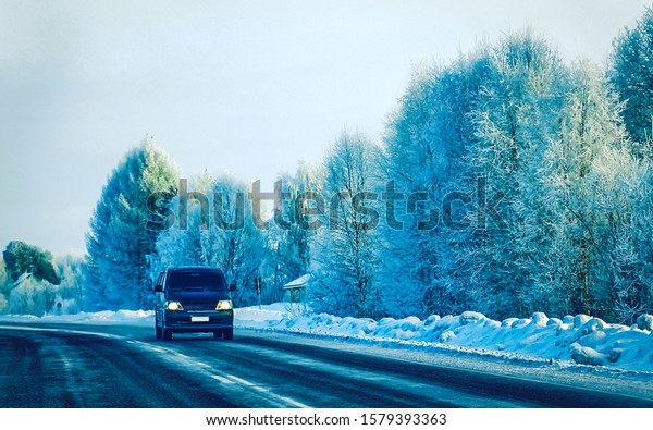 Mini Van on Winter road\
with snow in Finland. Car and cold landscape of Lapland. Europe\
forest. Finnish City highway ride. Roadway and route snowy street\
trip. Driving