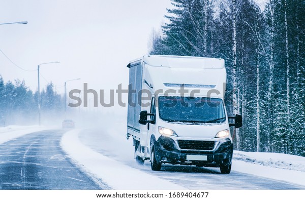 Mini\
van in a Snowy Winter Road in Finland in\
Lapland.