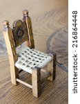Mini wooden hand made chair on carved table