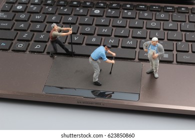 the Mini workmen repairing a laptop key board. - Powered by Shutterstock