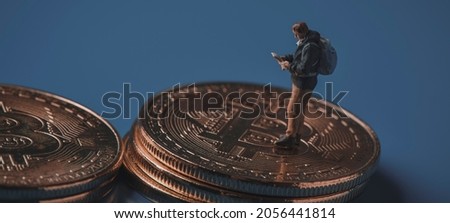 miniature adventurer man observing a map on a pile of bitcoins, depicting the adventurous and risky nature of investing in this virtual currency, in a panoramic format to use as web banner or header