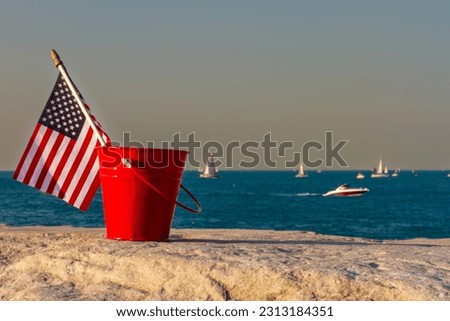 Miniature American flag sits in a bucket while boats go by at the Adler Planetarium Skyline Walk in Chicago