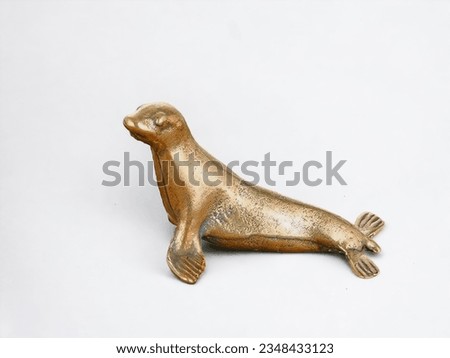 Miniature animal bronze seal statue on white background