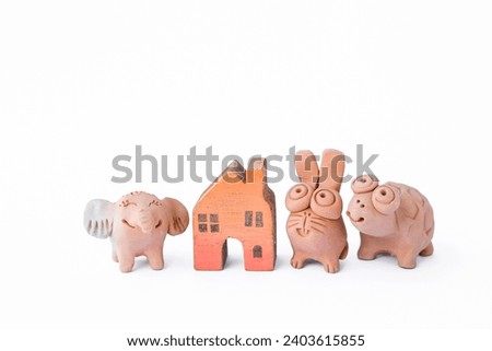 Miniature animal clay doll with wooden miniature house isolate on white background, garden decoration item, animal home
