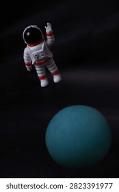 A miniature astronaut appears to float through deep space above a glowing blue planet, creating a whimsical and imaginative scene that evokes exploration, curiosity, and the wonder of the universe.