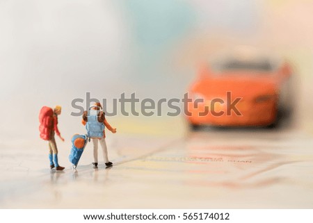Miniature backpacker on map with super car using as background travel or business concept.