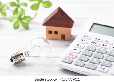 Miniature bulb and calculator on white board - Shutterstock ID 1787709011